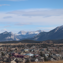 Description: A scenic view of the Rocky Mountains in the background and a small town in the foreground.