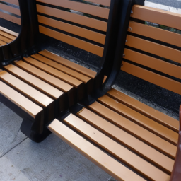 An outdoor bench with a backrest and armrests, made of wood or metal, with a foldable design.